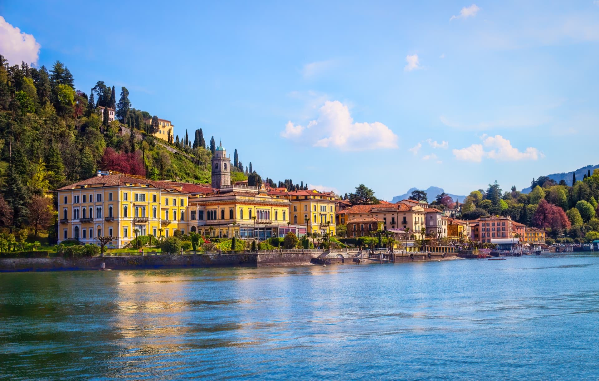 Bellagio's colorful lakefront houses and bell tower seen from the water on Lake Como